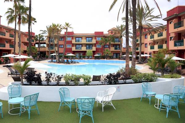 Außenpoolbereich des Bluesea Aloe Corralejo Hotels mit blauen Liegestühlen und weißen Sonnenschirmen.