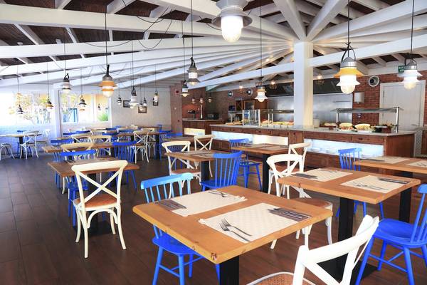 Innenansicht des Restaurants im O7 Aloe Corralejo Hotel mit blauen Stühlen und Holztischen.