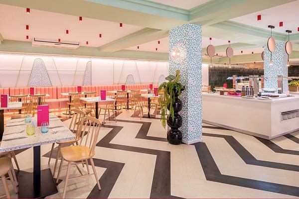 Innenansicht des Restaurants im Aparthotel Allegro Isora mit gemusterten Wänden und Möbeln.