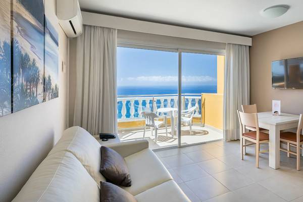 Wohnzimmer im Aparthotel Allegro Isora mit Balkon und Meerblick.