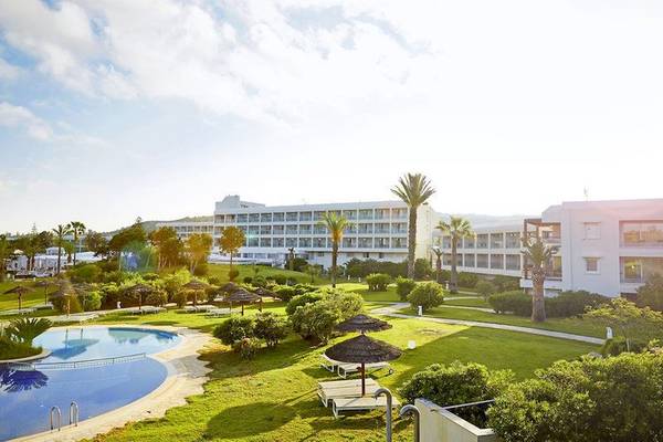 Außenansicht des Robinson Kyllini Beach Hotels mit Pool, Sonnenliegen und Palmen