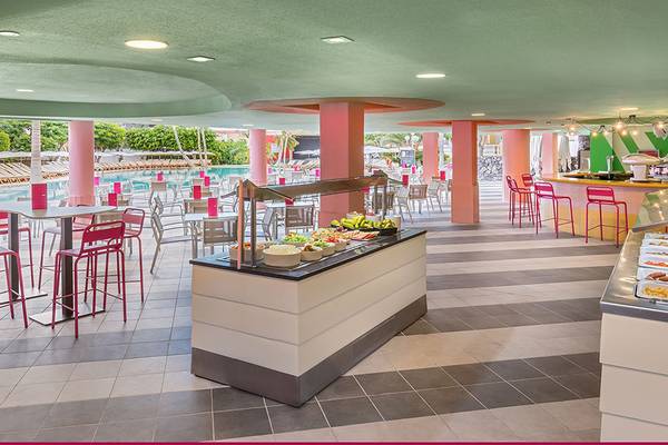 Restaurantbereich des Aparthotel Allegro Isora mit bunten Stühlen und Tischen, Buffet mit verschiedenen Speisen.