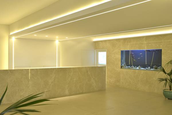 Empfangsbereich des Sunrise Gardens Hotels mit heller Beleuchtung und Fischaquarium