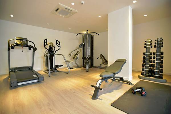 Fitnessraum im Sunrise Gardens Hotel mit Laufband, Crosstrainer, Hantelbank und Hanteln.