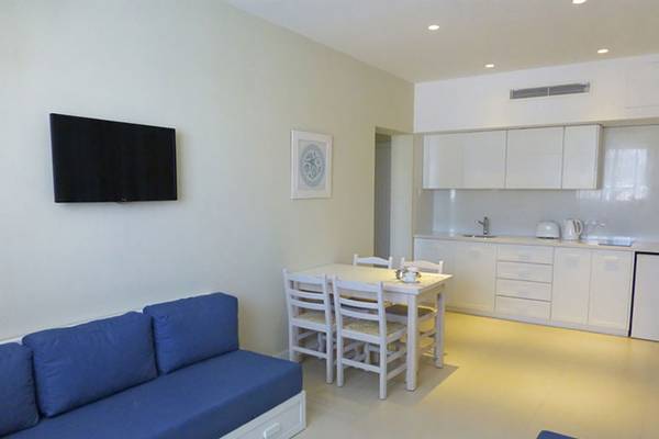 Wohnzimmer mit Tisch und Sofa in Sunrise Gardens Hotel.