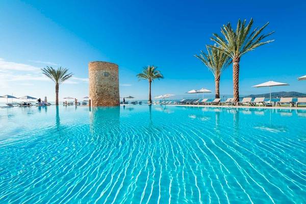 Außenpool des Torre del Mar Hotels mit Sonnenliegen und Palmen