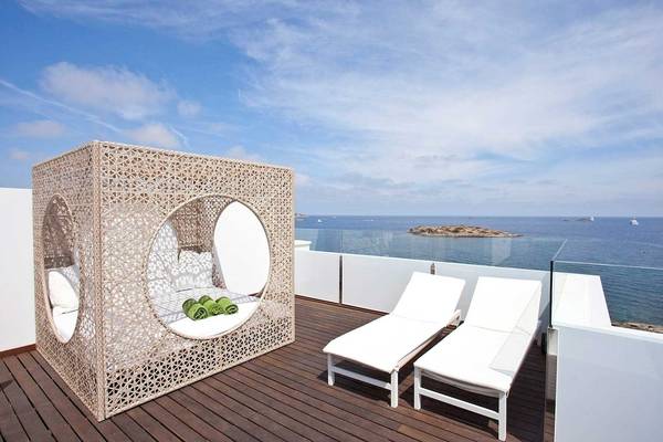 Terrasse mit einem Bett und Liegestühlen am Torre del Mar Hotel mit Blick auf das Meer.