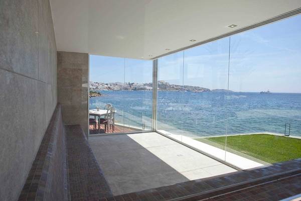 Terrasse mit Meerblick im Torre del Mar Hotel, mit Tischen und Stühlen, die zum Sitzen einladen.