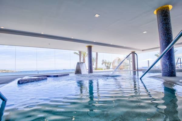 Innenpool des Torre del Mar Hotels mit großer Glasfront und Meerblick
