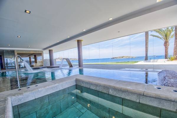 Innenpool des Torre del Mar Hotels mit Meerblick und Palmen im Hintergrund.