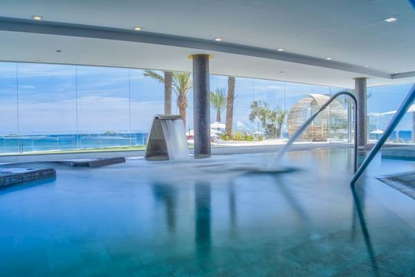 Innenpool des Torre del Mar Hotels mit Blick auf das Meer und Palmen