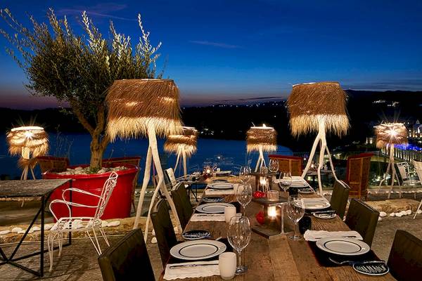 Restaurant des Myconian Avaton Resorts bei Nacht mit Blick auf das Meer und die Stadt