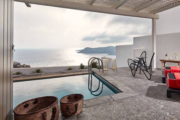 Terrasse des Myconian Avaton Resorts mit Pool und Meerblick, Loungemöbeln und Dekogegenständen.
