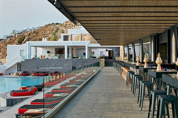 Poolseite Bar im Myconian Avaton Resort mit Loungeliegen und Tischen unter einer Pergola