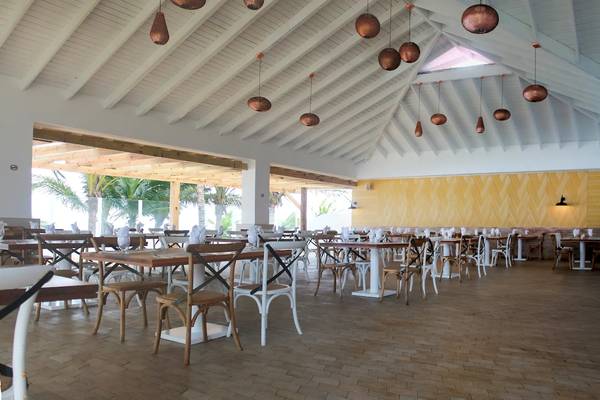 Innenansicht des Restaurants im Viva Tangerine by Wyndham Hotel mit runden Tischen und Stühlen.