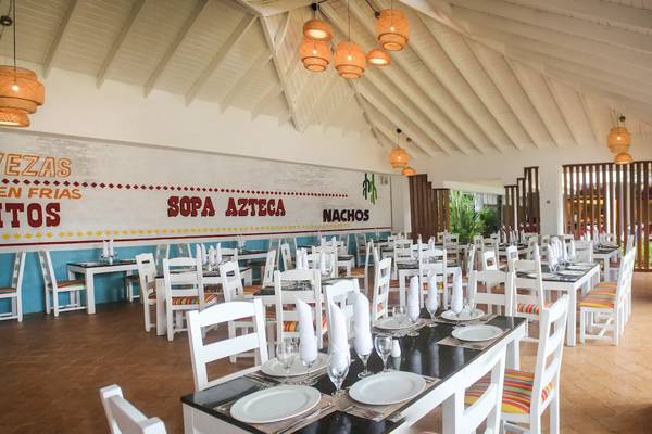 Innenansicht des Viva Tangerine by Wyndham Restaurants mit weiß gestrichenen Wänden und bunten Sitzplätzen.