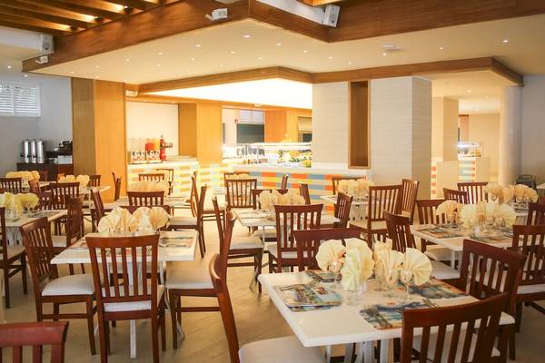 Innenansicht des Restaurants im Viva Tangerine by Wyndham Hotel mit gedeckten Tischen und Stühlen.