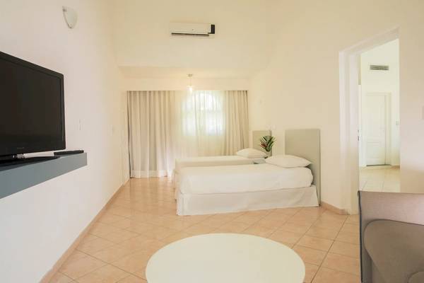 Ein Hotelzimmer im Viva Tangerine by Wyndham mit zwei Betten, einer Couch und einem Fernseher.