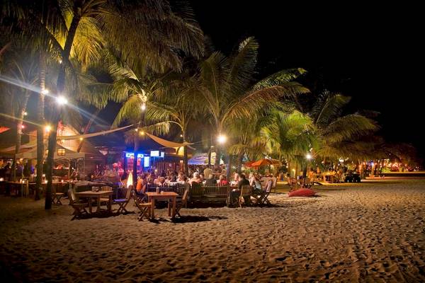 Viva Tangerine Beach Bar bei Nacht mit vielen Gästen, die an Tischen sitzen und essen.