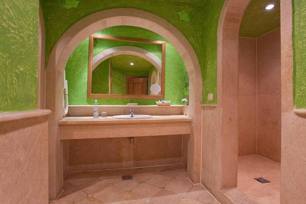 Badezimmer im Makadi Palace mit grünen Wänden, einem Spiegel und einer Dusche.