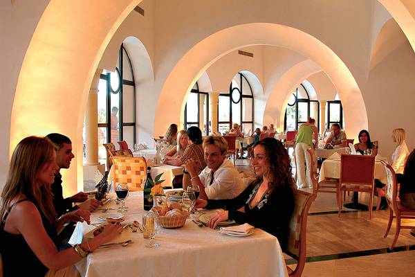 Gruppe von Gästen, die in einem eleganten Restaurant des Makadi Palace sitzen und essen.