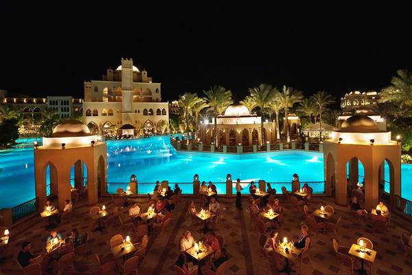 Makadi Palace Hotelpool bei Nacht mit illuminierten Tischen und Palmen