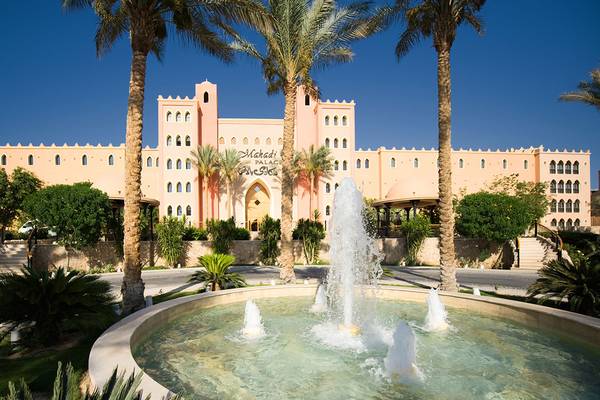Makadi Palace Hotel mit Brunnen und Palmen vor dem Eingang.