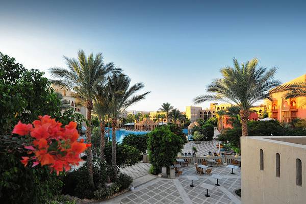 Aussicht auf den Poolbereich des Makadi Palace Hotels mit Palmen und Gebäuden.