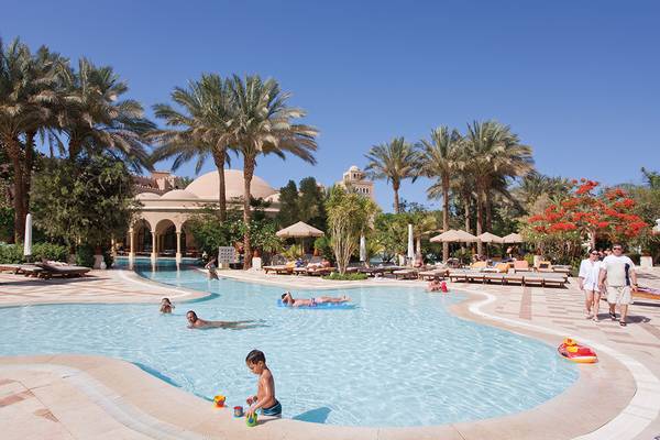 Der Poolbereich des Makadi Palace Hotels mit mehreren Schwimmern und Liegestühlen.