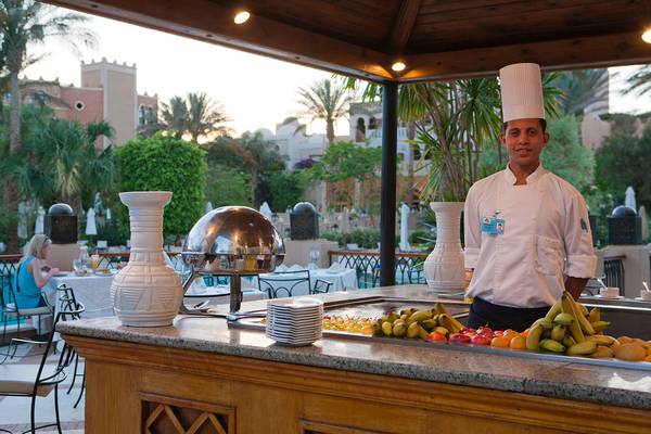 Koch im Makadi Palace serviert Obst an einem Buffet.