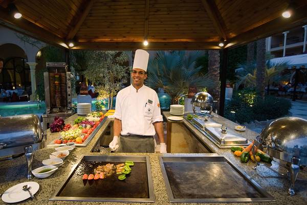 Koch im Makadi Palace bereitet ein Gericht auf dem Grill zu.