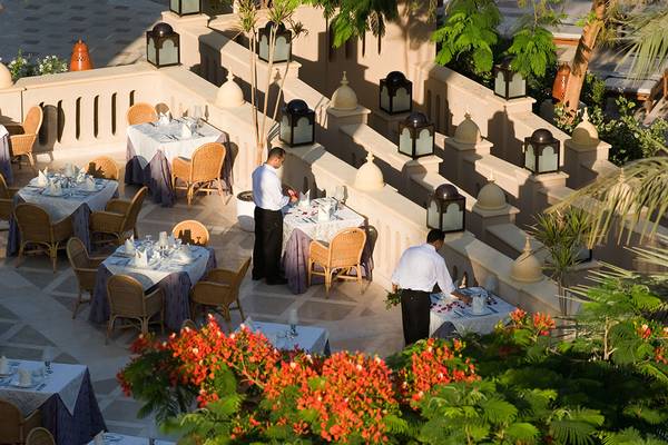 Makadi Palace Terrassenrestaurant mit gedeckten Tischen, Kellnern und dekorativen Laternen.