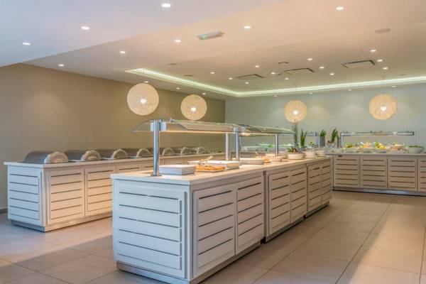 Buffetbereich im Nissi Beach Resort mit verschiedenen Speisen und modernen Möbeln.