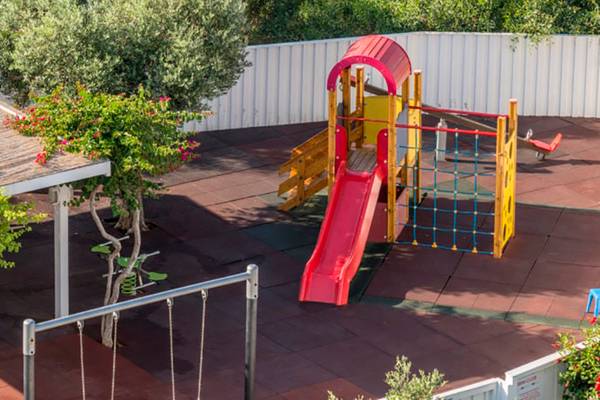 Kinderspielplatz im Nissi Beach Resort mit Rutsche, Schaukel und Klettergerüst.
