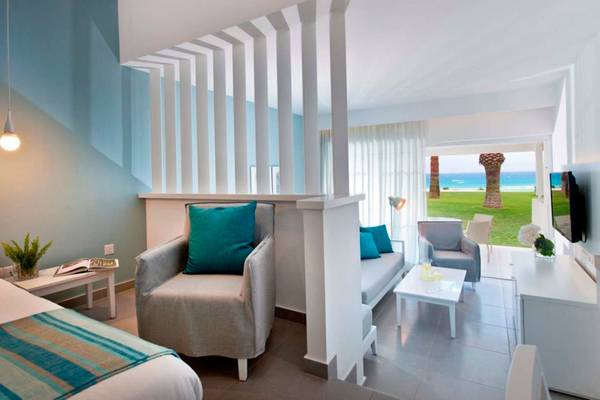 Innenansicht eines Zimmers im Nissi Beach Resort mit Blick auf das Meer.