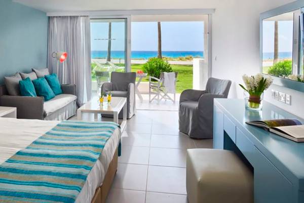 Hotelzimmer im Nissi Beach Resort mit Meerblick, Doppelbett, Wohnzimmer und Terrasse