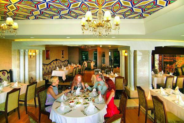 Gäste essen im Royal Dragon Hotel an einem Tisch mit verschiedenen Gerichten.