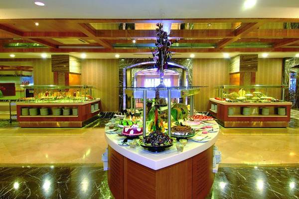 Buffetbereich im Royal Dragon Hotel mit verschiedenen Speisen und Kuchen.