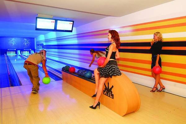 Royal Dragon Hotel Bowlinghalle mit bunten Wänden und Spielenden.