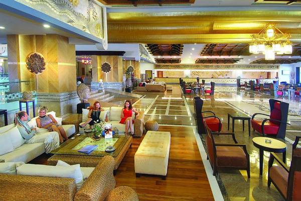 Innenbereich der Hotellobby im Royal Dragon Hotel mit mehreren Gästen auf Sofas.