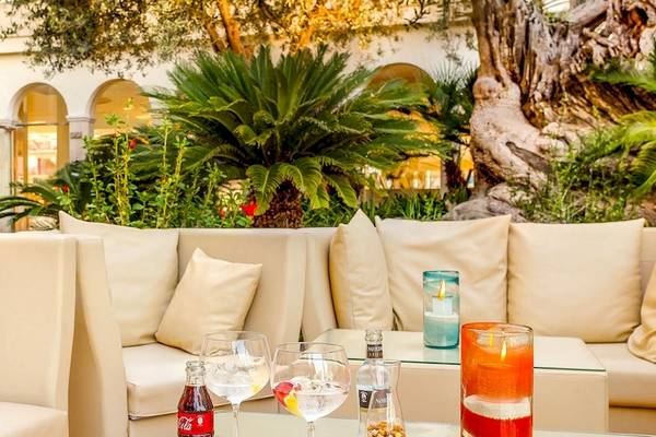 VIVA Golf Adults Only Hotel Lounge mit weißen Sofas, Kissen, und Pflanzen im Hintergrund.