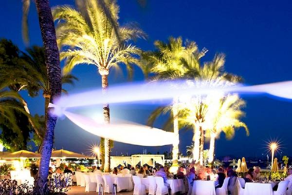 Dinner im Freien im VIVA Golf Adults Only Hotel bei Nacht mit beleuchteten Palmen und Gästen an Tischen.