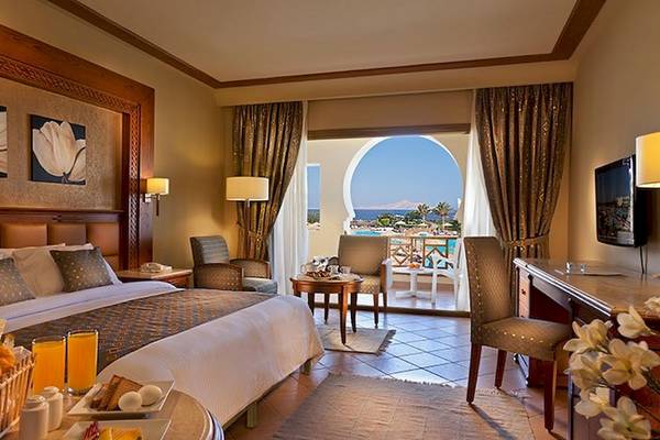 Charmillion Club Resort Hotelzimmer mit großem Bett, Balkon und Meerblick.