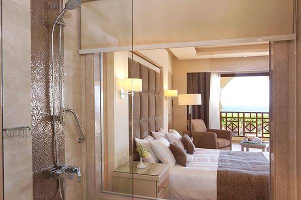 Charmillion Club Resort Hotelzimmer mit Balkon, Bett, Dusche und Wohnzimmer.