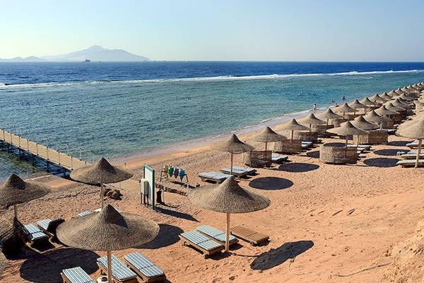 Strand des Charmillion Club Resorts mit vielen Sonnenschirmen und Liegestühlen