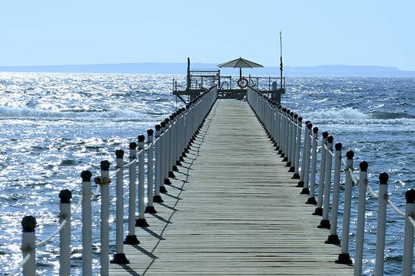 Charmillion Club Resort: Holzsteg mit Leuchtturm und Rettungsring im Meer
