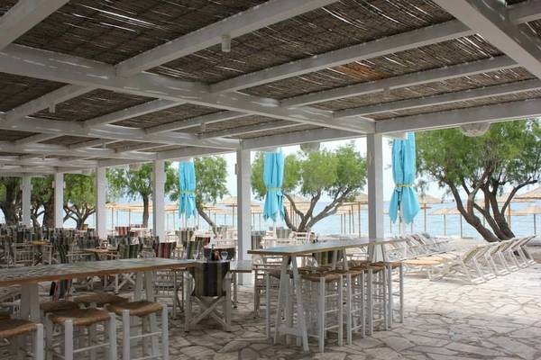 Überdachte Terrasse im Doryssa Seaside Resort mit Blick auf den Strand und das Meer.