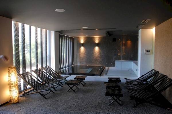 Innenbereich des Doryssa Seaside Resort mit Lounge-Stuhlreihen und Whirlpool.