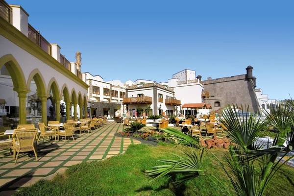 Außenbereich des Gran Castillo Tagoro Family & Fun Hotels mit Terrassen, Tischen und Stühlen.