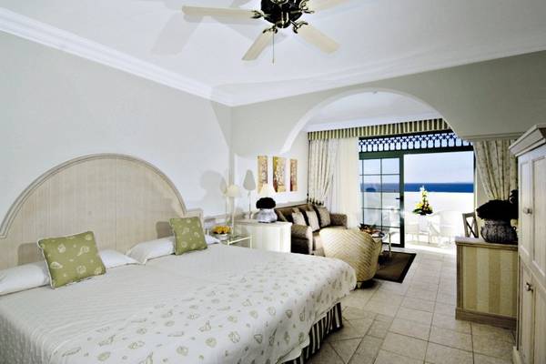 Schlafzimmer im Gran Castillo Tagoro Family & Fun Hotel mit großem Bett und Meerblick.